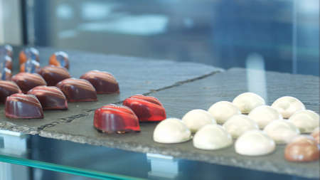 Shop window with stacks of chocolate sweets, jellies and candiesの写真素材