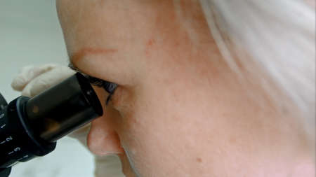 Scientist looking in microscopeの写真素材