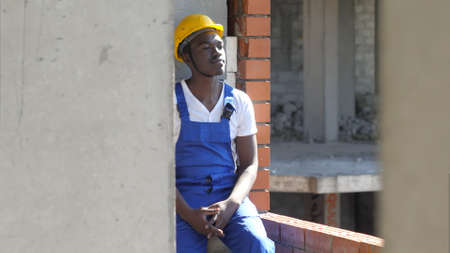 Young afro-american construction worker takes a break during workの写真素材