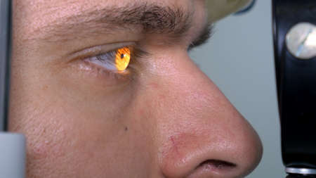 Young man checks the eyes on the modern equipment in the medical centerの写真素材