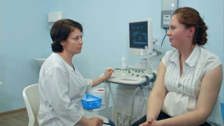 Young woman telling female doctor about her symptomsの写真素材