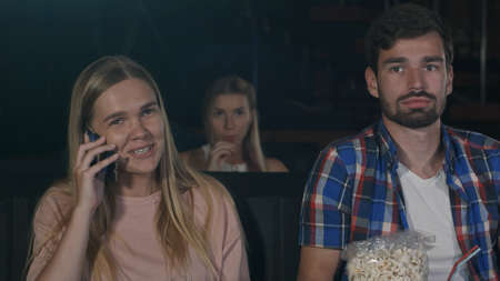 Annoying woman on the phone during movie at the cinemaの写真素材