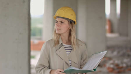 Female engineer is angry and upset reading construction planの写真素材