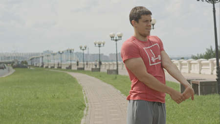 Warming up before jogging while standing outdoorsの写真素材