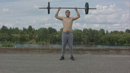 Man working out outdoors with barbellの写真素材