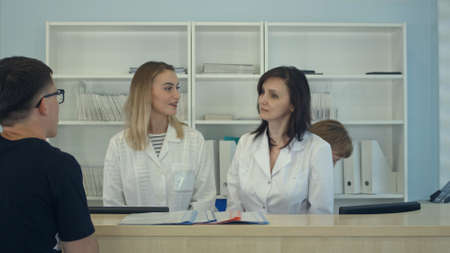 Medical staff working around busy medical reception deskの写真素材