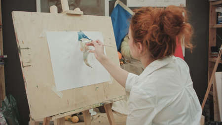 Young female artist painting still life in studioの写真素材