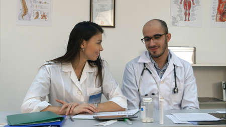 Smiling nurse and her male coworker trying to use tablet but its not workingの写真素材