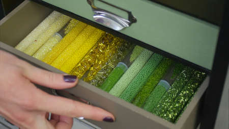 Beads for jewelry and jewelry in transparent jars. Close up.の写真素材