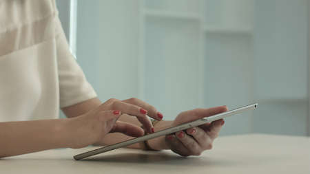 Woman sitting in office table and touch tablet