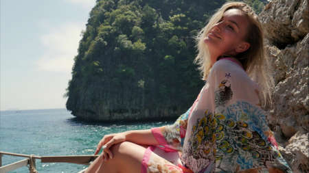 Beautiful young woman posing in photo session with the sea and rocks as a background at Phi Phi islandsの写真素材