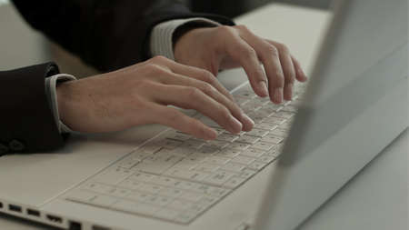 Man typing on laptop computer keyboardの写真素材