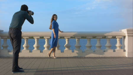 Woman in blue dress posing for photographer.の写真素材