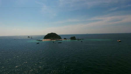 Copter flies to the beach full of people and boats at summer dayの写真素材