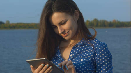 Woman outdoor using digital tablet. Closeup.の写真素材