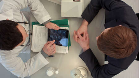 Top view of Doctor reviewing x-ray with patientの写真素材