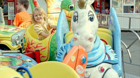 Girl riding a colorful carouselの写真素材