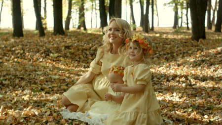 Mother with children n in sunny autumn parkの写真素材