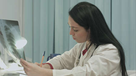 Female x-ray technician analyzing some results and taking notesの写真素材