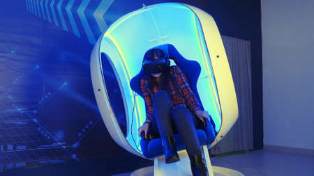 Young girl sitting in virtual reality attraction and feeling scaryの写真素材