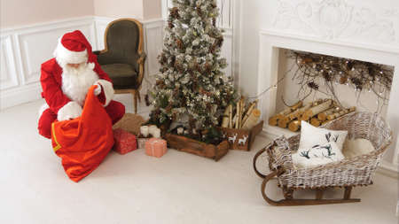 Santa delivering presents under the Christmas treeの写真素材