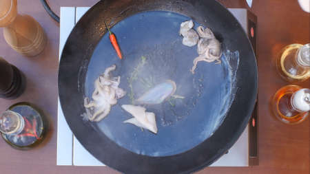 Putting fresh seafood in frying panの写真素材
