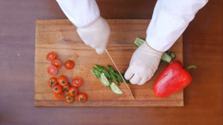 Cutting cucumber on a wooden boardの写真素材
