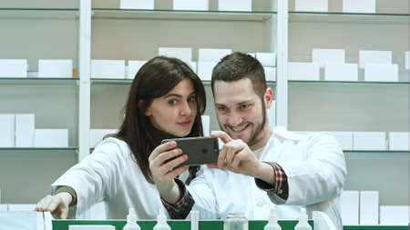 Smiling two pharmacist taking selfie in pharmacyの写真素材