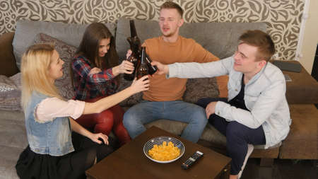 Group of students clinking bottles of beerの写真素材