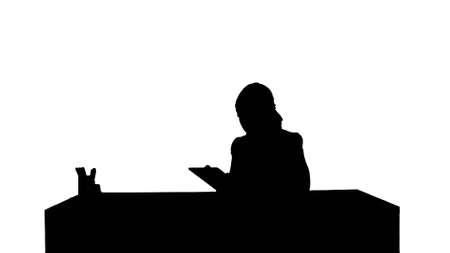 Silhouette Business woman sitting in her office using a tablet computerの写真素材