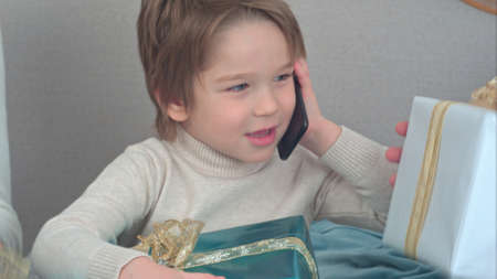 Little boy talking on the phone describing presents he got for Christmasの写真素材