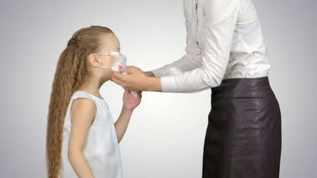 Mother and daughter wearing surgical masks to protect from an epidemic on white backgroundの写真素材
