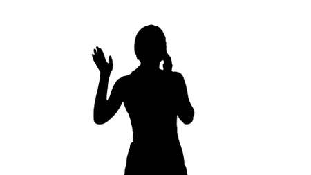 Silhouette Portrait of happy young Woman Talking On Mobile Phoneの写真素材