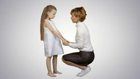 Mother and daughter talking on white backgroundの写真素材
