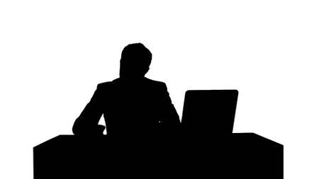 Silhouette Human hand writing on a paper with laptopの写真素材