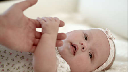 Happy mother holding her baby handの写真素材