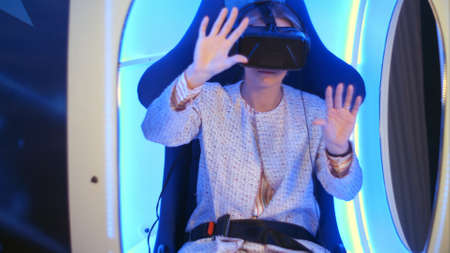 Young woman in virtual reality headset preparing for vr sessionの写真素材