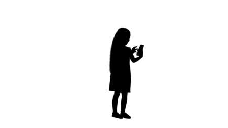 Silhouette Cute little girl uses a smartphone and laugh track matteの写真素材