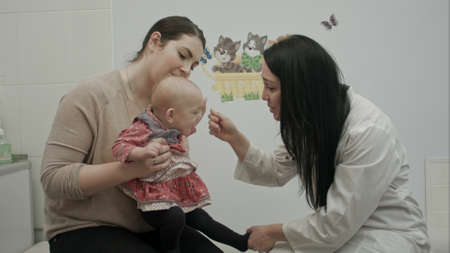 doctor talking with a young mother and her newborn babyの写真素材