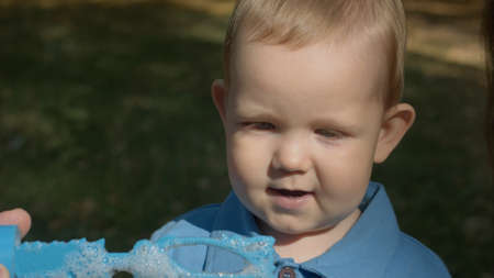 Cute boy blowing soap bubbles.の写真素材