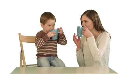Son with his mother drinking tea on white background isolatedの写真素材