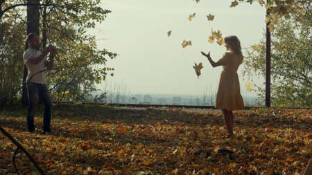 Lovers with autumn maple leaves in parkの写真素材