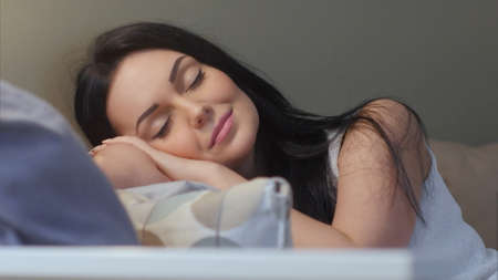 Beautiful brunette falls asleep on the couch at homeの写真素材