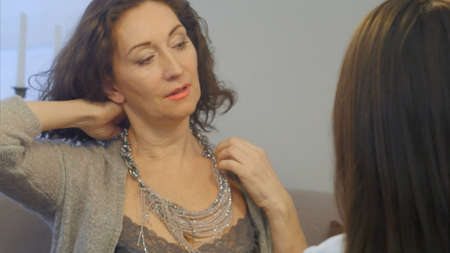 Woman appraise necklaces, chains, bracelets in jewelry storeの写真素材