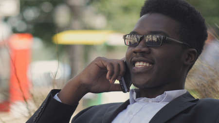 Handsome african american man laughs and talks on his cell phone