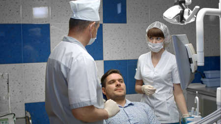 A team of dentists with client in a dental officeの写真素材