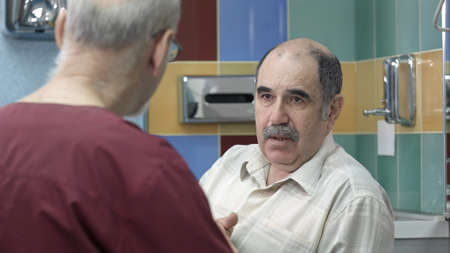 Doctor talking to senior male patient at officeの写真素材
