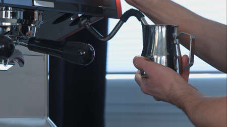 Professional barista shaking milk in coffee shopの写真素材