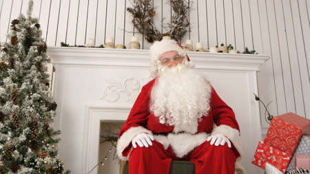 Santa greeting children and talking about Christmas looking at the cameraの写真素材