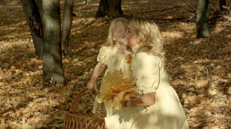 Happy young mother with daughter in autumn parkの写真素材